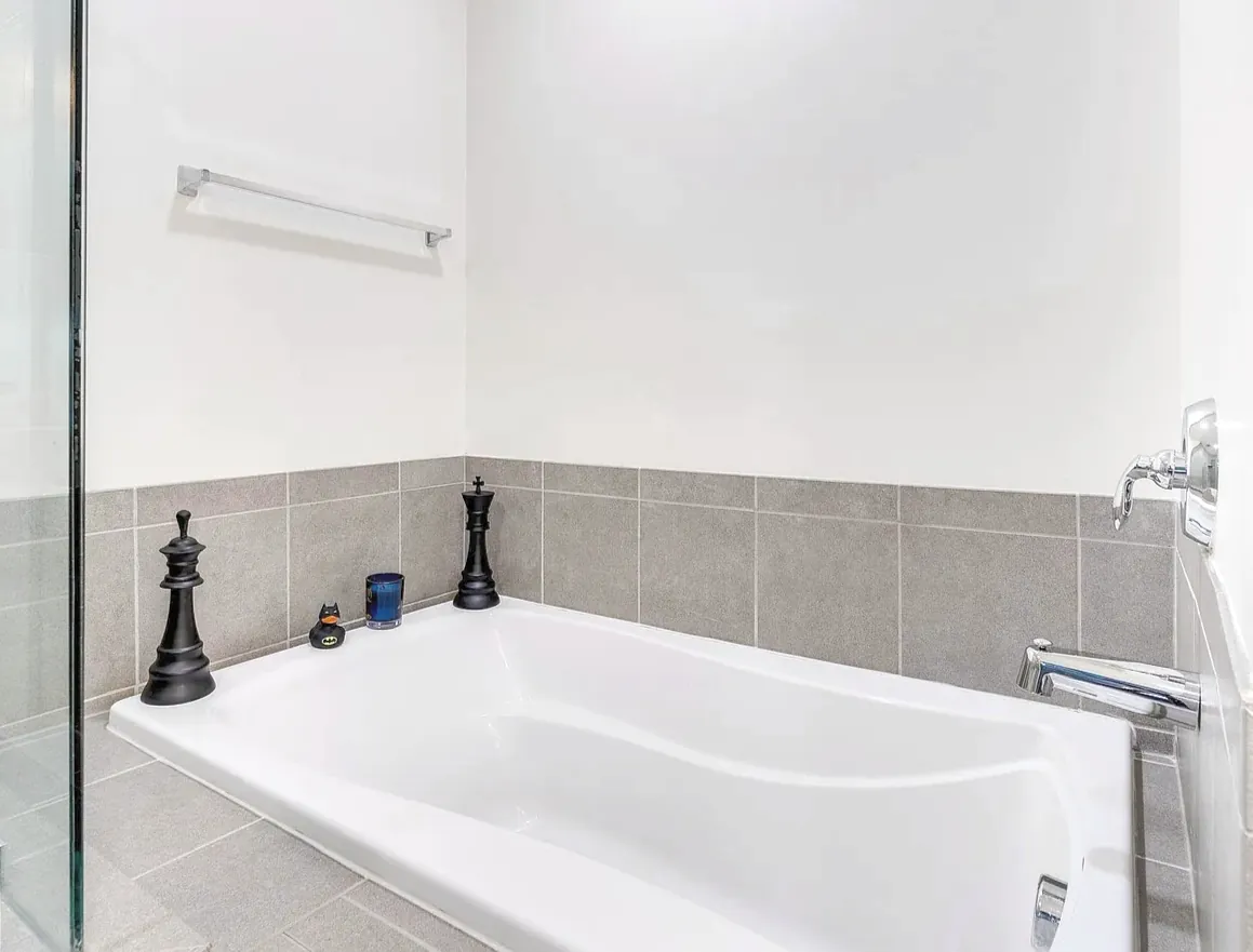 Spotless white soaking tub with a gray tile surround after a deep cleaning by TCS Cleaning Service