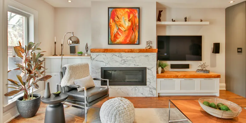 Living room with a marble fireplace and wood floors, the kind of living space guests walk into after a turnover cleaning