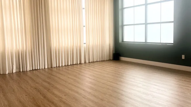 Empty room with a clean wood floor and sunlit curtains, ready for a move-out or move-in cleaning in Maryland