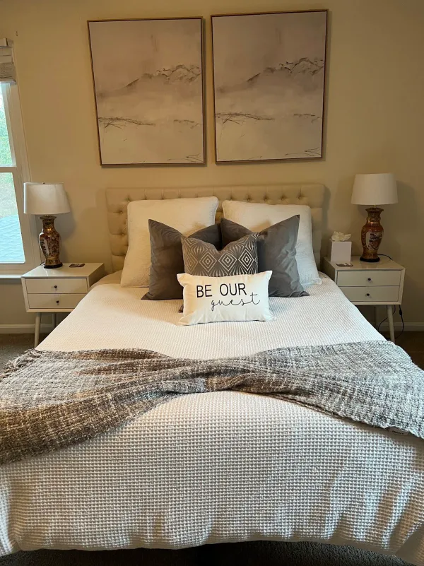 Guest bedroom with a neatly made bed, gray pillows and matching nightstands (House Cleaning by TCS Cleaning Service)