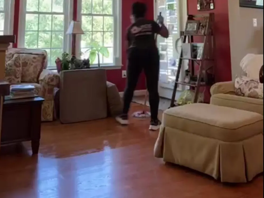 A TCS Cleaning Service team member cleaning a living room during a house cleaning in Maryland