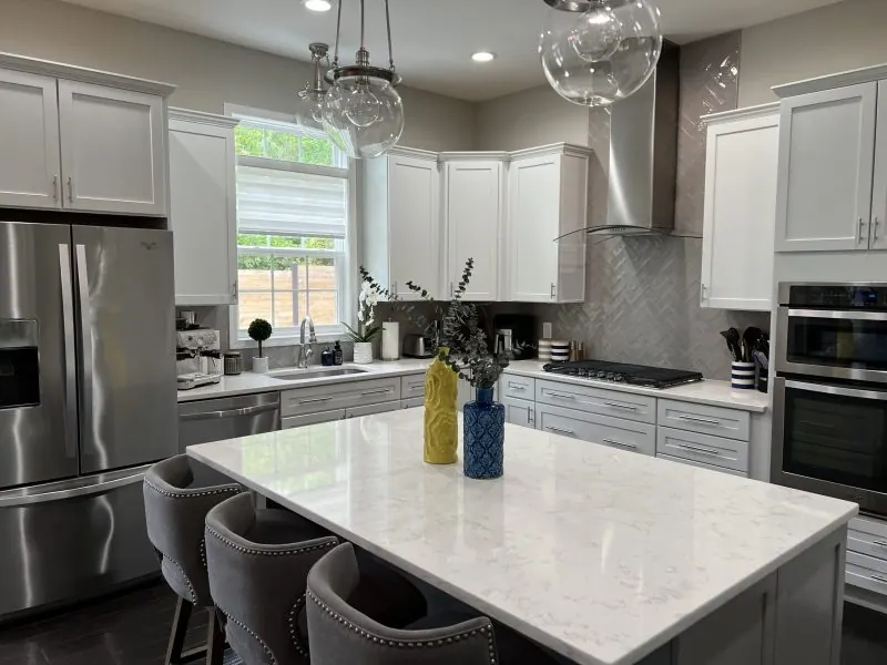 White kitchen with marble island and stainless steel appliances, freshly cleaned