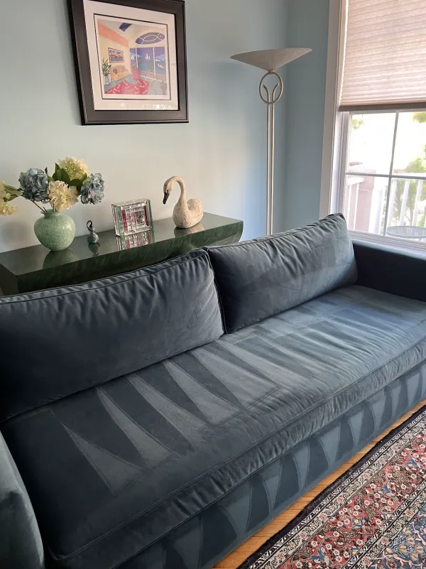 Blue velvet sofa with fresh vacuum lines in a light blue living room